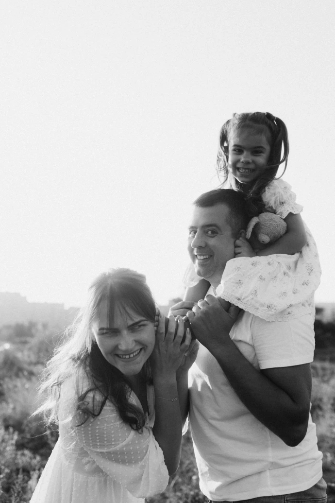 A couple of people that are standing in the grass